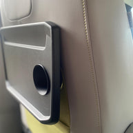 Side view of ID. Buzz rear tray cup hole, 3D printed insert fits securely, car tray without holder, custom van accessory potential, drink stabilizer missing, before upgrade view